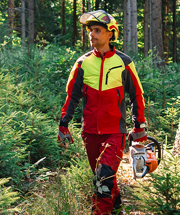 Une personne en tenue de protection rouge et jaune entaille un arbre avec une tron�onneuse dans la for�t.